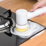 Električna četka za čišćenje u upotrebi na kuhinjskom šporetu — uklanjanje masnih naslaga
