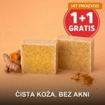 Prirodni sapun od kurkume na drvenom postolju pored svežeg korena kurkume
