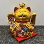 Maneki-neko figura — zlatna mačka koja maše na baterije